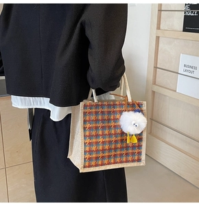 Close-up of retro plaid canvas handbag with woven rope handle and plush charm detail