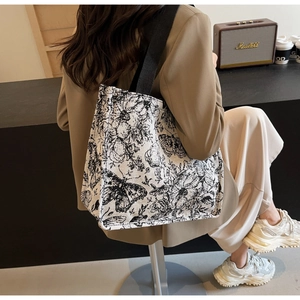Detail view of large capacity canvas tote bag with black and white floral butterfly print