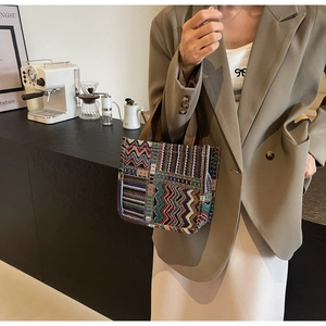 Detail of vintage tote bag featuring colorful geometric patterns and woven handles