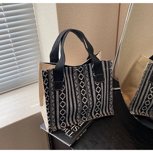 Detail of geometric pattern tote bag with cotton-linen texture and black woven handles