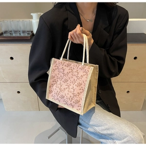 Dettaglio di borsa floreale rosa con base in lino e manici in corda di cotone bianco