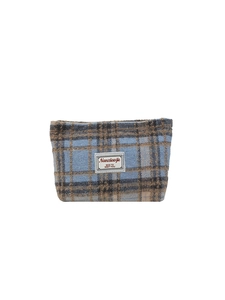 Blue and brown plaid tweed cosmetic bag with brand label on a clean white background