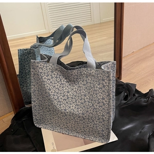 Détail du sac cabas en jacquard bleu avec motifs floraux blancs et texture de tissu tissé