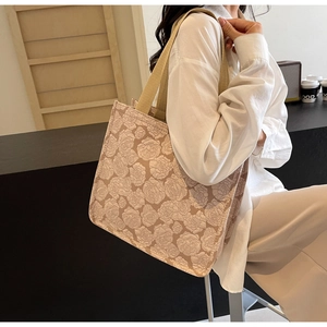 Détail de la texture jacquard rose beige et de la bandoulière tissée sur un grand cabas