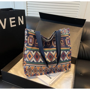 Detailed close-up of ethnic woven tote bag with colorful geometric patterns in gift box