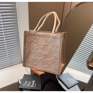 Detail of light brown floral embossed tote bag with thick cotton rope handles