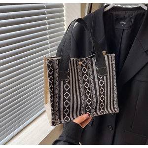 Detail of hand-held ethnic tote bag with black and white geometric woven patterns