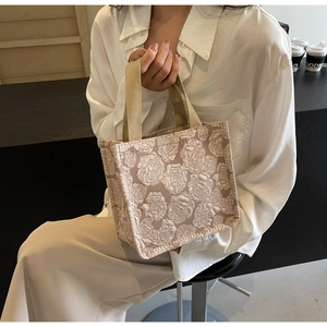Gros plan détaillé d'un sac cabas beige avec un motif de fleurs roses en relief 3D