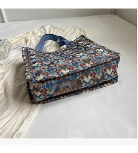 Detail of bohemian woven tote bag showing geometric multi-color pattern and side volume