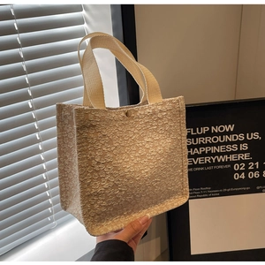 Détail du sac cabas crème avec tissu texturé pop-corn et fermoir en métal
