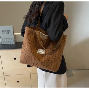Détail du sac cabas en velours côtelé marron à fleurs porté à l'épaule pour femme