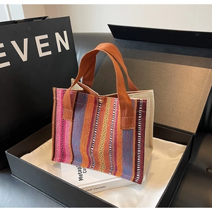 Detailed shot of ethnic striped canvas tote bag with magnetic clasp on satin lining
