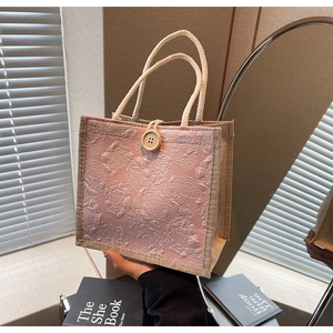 Detail of pink rose jacquard linen handbag with wood button closure and rope handles