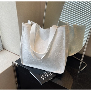 Gros plan du sac cabas en jacquard blanc avec motifs floraux et poignées tissées