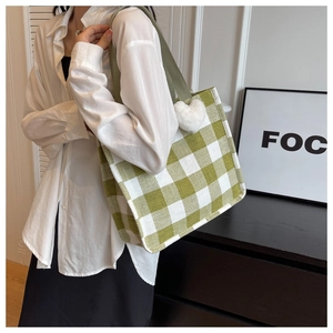 Sac fourre-tout à damier vert et blanc avec breloque cœur blanc porté par un mannequin