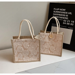 Detailed macro view of 3D rose floral jacquard texture and woven rope handle on linen tote