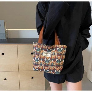 Detail of bohemian geometric jacquard fabric and durable brown ribbon handles on a tote bag