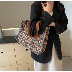 Detail of bohemian tote bag with geometric patterns and orange woven shoulder straps
