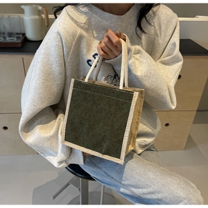 Dettaglio della borsa floreale con pannello verde, lati in lino e manico in corda