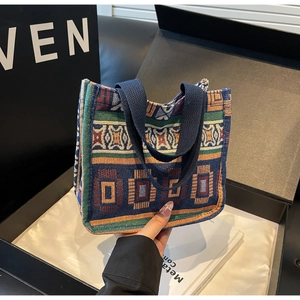 Close-up of geometric woven pattern and durable canvas strap on a vintage tote bag
