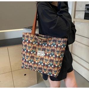 Close-up of bohemian tote bag with colorful geometric jacquard patterns and a brand tag