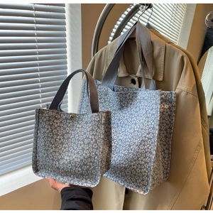 Vue détaillée de deux sacs cabas en toile fleurie bleu clair de différentes tailles