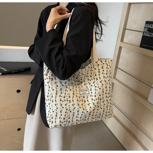 Détail du sac fourre-tout en velours côtelé à fleurs avec motifs bruns et écusson textile