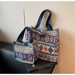 Close-up of ethnic geometric embroidered tote bag set on a leather sofa surface
