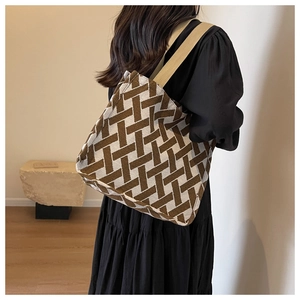 Detail of geometric knit pattern on tote bag with wide beige shoulder strap