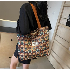 Detail of bohemian tote bag with geometric pattern and wide orange shoulder strap