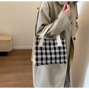 Detail of checkered woven tote bag with canvas side and magnetic snap closure