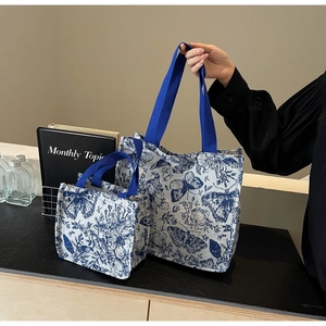 Detail of canvas tote bags set featuring blue vintage floral butterfly prints and web handles