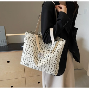 Gros plan du sac fourre-tout à motif floral avec étiquette tissée et large bandoulière