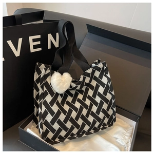 Detail of woven tote bag with heart charm presented in a premium gift box set