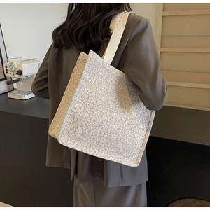 Gros plan détaillé du grand sac cabas en maille à fleurs avec bandoulière tissée robuste