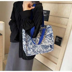 Side view of large floral canvas tote bag with blue butterfly print and webbing handles