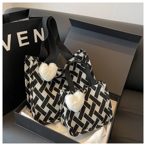 Detail of woven tote bag set with heart charm in a premium gift box presentation