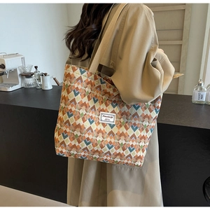 Detail of bohemian tote bag with geometric diamond patterns and wide shoulder strap