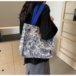 Detail of the blue floral butterfly print and sturdy handles on the canvas tote bag