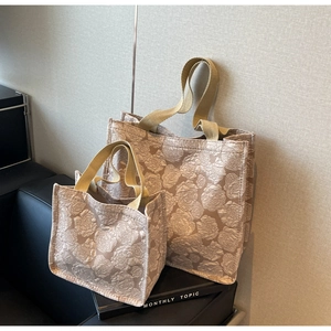 Détail du sac cabas champagne avec gaufrage de roses et poignées en sangle tissée