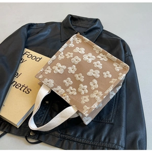 Detailed shot of khaki tote bag with white 3D floral embroidery and stylish metal snap button