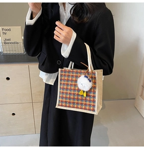 Close-up of mini linen tote bag featuring orange and blue plaid with a cute chick plush charm