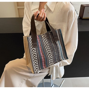 Detail of bohemian geometric woven tote bag with durable dark brown webbed handles