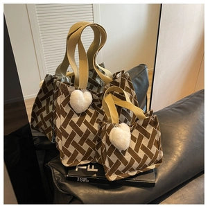 Detail showing two sizes of brown and white woven knit tote bags with plush heart charms