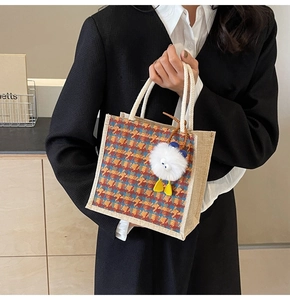 Close-up of linen tote bag with colorful geometric patterns and a cute plush charm