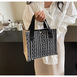 Detail of woven tote bag featuring black and white geometric ethnic patterns and canvas sides