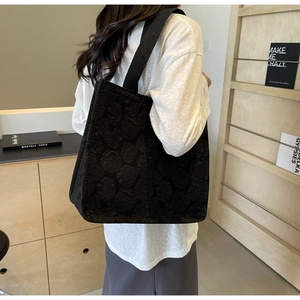Détail du sac cabas noir avec jacquard de roses en relief et larges bandoulières