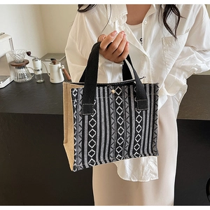Detail of woven ethnic tote bag with black and white patterns and magnetic snap closure