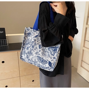 Detailed view of canvas tote bag with blue butterfly floral print and durable ribbon handle