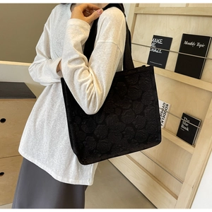 Détail macro de la texture jacquard à roses 3D sur ce sac cabas noir pour femme